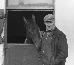 GINGER McCAIN WITH RED RUM PICTURED AT HIS STABLES BEHIND SECOND HAND CAR SHOWROOM. SOUTHPORT 1975. pic by George Selwyn,119 Torriano Ave,London NW5 2RX.T:+44 (0)207 267 6929 M: 07967 030722 email: george@georgeselwyn.co.uk Vat no:3308110 05